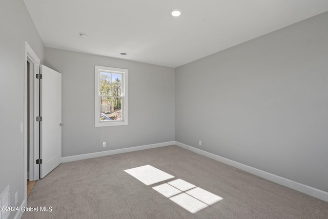 empty room with light carpet, baseboards, recessed lighting, and a smoke detector