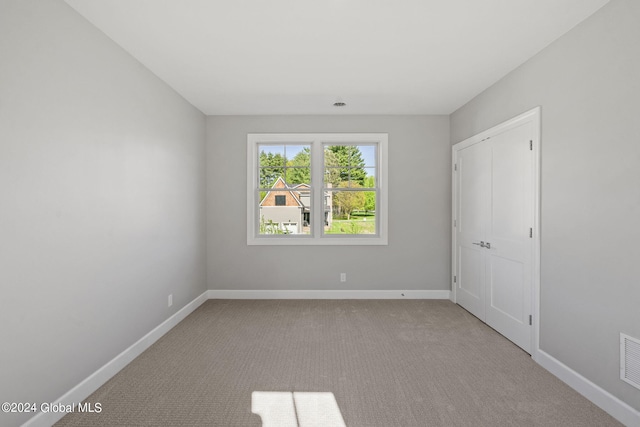 unfurnished room with baseboards and carpet