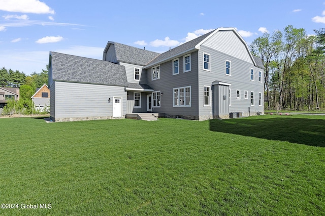 back of house featuring a yard, a shingled roof, and central air condition unit