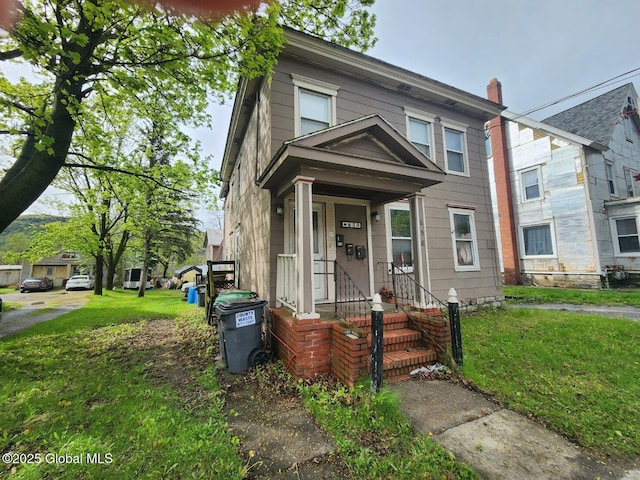 view of front facade with a chimney and a front yard