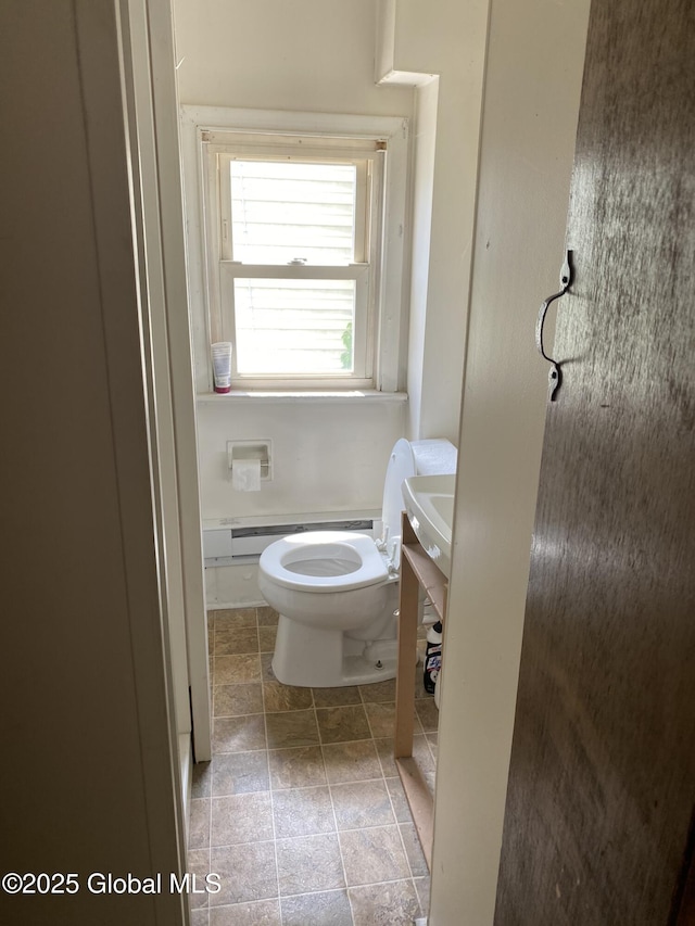 bathroom with toilet and stone finish flooring