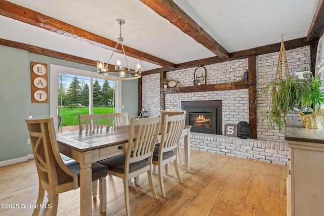 228 Maura Ln, Glenville, NY 12302 - dining room featuring light wood-style flooring, a brick fireplace, a chandelier, beamed ceiling, and brick wall