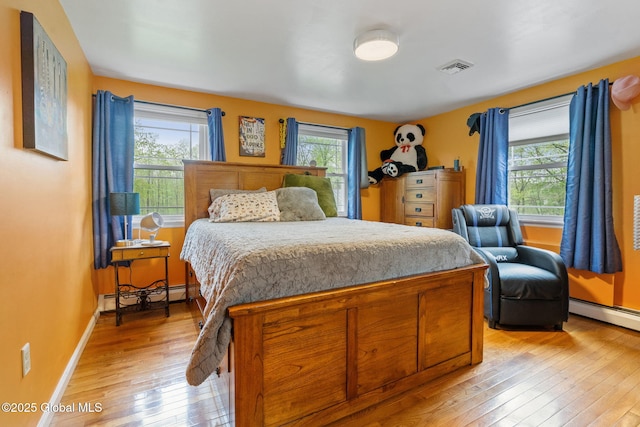 228 Maura Ln, Glenville, NY 12302 - bedroom featuring baseboard heating, light wood-style floors, and multiple windows