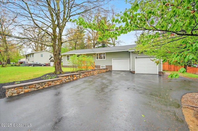 ranch-style home featuring fence, a garage, a front lawn, and driveway