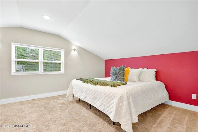 carpeted bedroom featuring baseboards and lofted ceiling