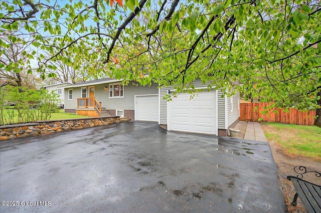 view of front of house featuring fence and aphalt driveway