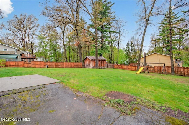 view of yard featuring a playground, a patio, and a fenced backyard