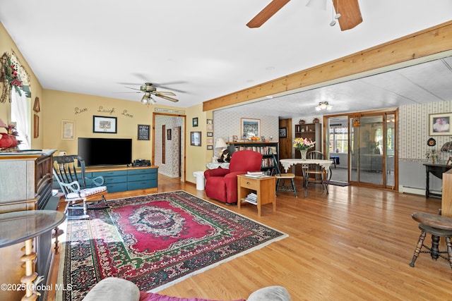 28 Buyce Cross, Thurman, NY 12810 - living area featuring a ceiling fan, wood finished floors, a baseboard radiator, and wallpapered walls