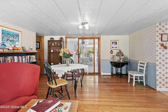 28 Buyce Cross, Thurman, NY 12810 - dining room featuring wallpapered walls, wood finished floors, and a baseboard radiator