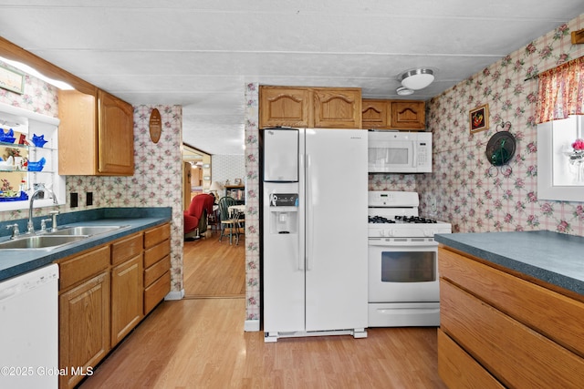 28 Buyce Cross, Thurman, NY 12810 - kitchen featuring white appliances, wallpapered walls, a sink, light wood-style floors, and dark countertops