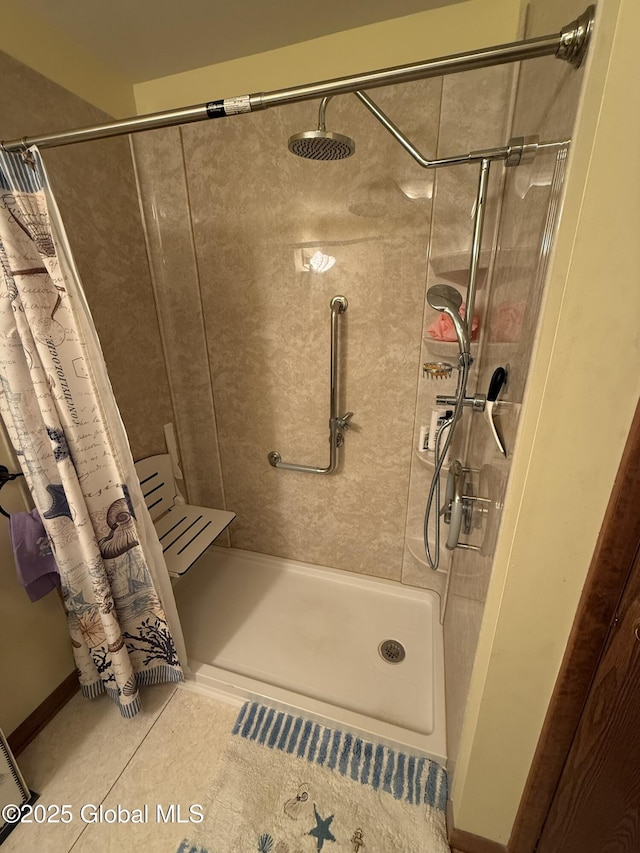 bathroom with a shower stall and tile patterned floors