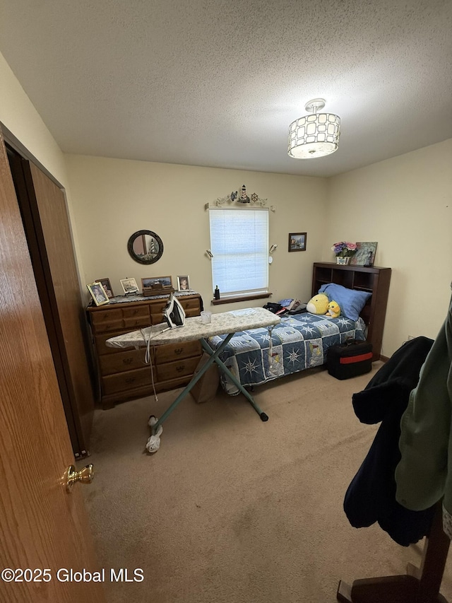 bedroom featuring carpet, a textured ceiling, and a closet