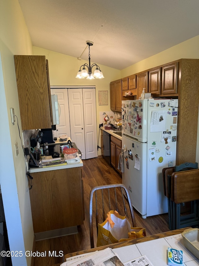 kitchen with freestanding refrigerator, dishwasher, lofted ceiling, dark wood-style floors, and brown cabinetry