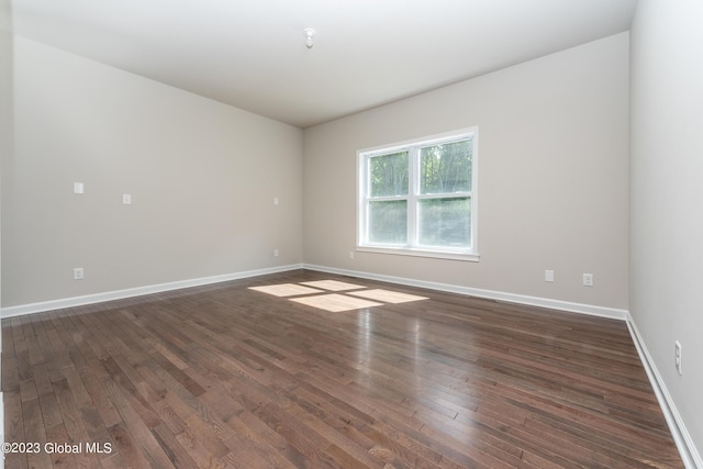 unfurnished room with wood finished floors and baseboards