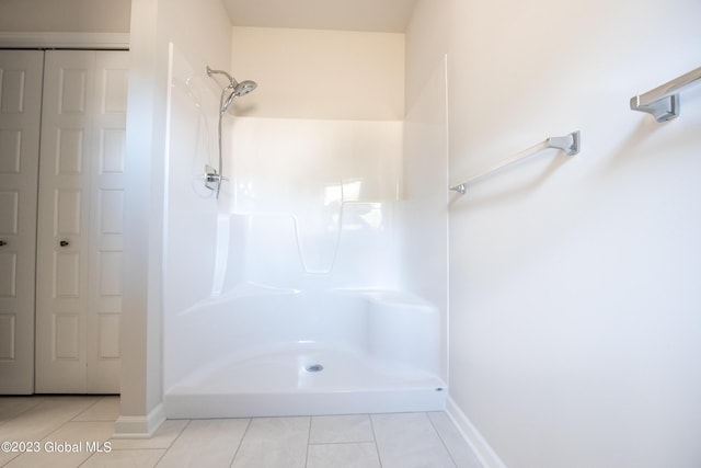 bathroom with walk in shower, tile patterned flooring, and baseboards