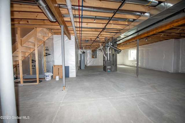 basement with electric panel, heating unit, and gas water heater