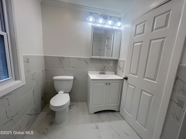 half bathroom with ornamental molding, toilet, marble finish flooring, vanity, and a wainscoted wall