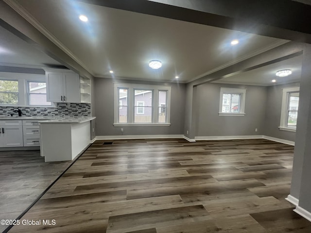 kitchen with ornamental molding, white cabinets, baseboards, plenty of natural light, and recessed lighting