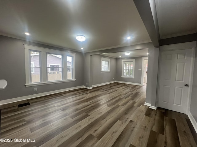 unfurnished living room featuring crown molding, baseboards, dark wood-style flooring, and recessed lighting