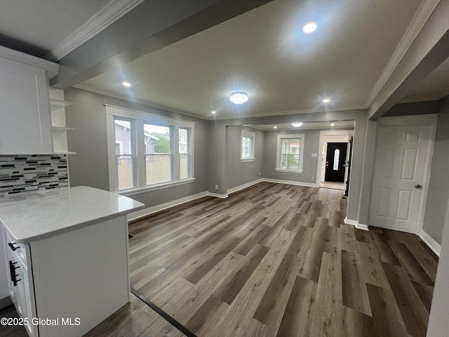 unfurnished dining area featuring crown molding, baseboards, dark wood-type flooring, and recessed lighting