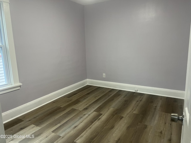 empty room with baseboards and dark wood-style flooring