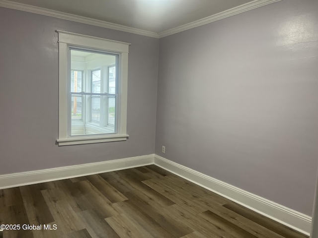 spare room with baseboards, dark wood finished floors, and crown molding