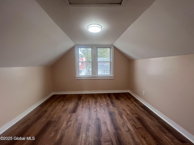 bonus room with dark wood-type flooring, baseboards, and lofted ceiling
