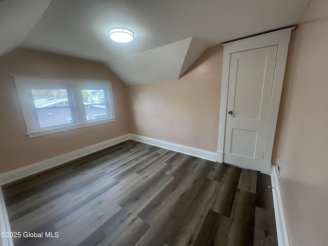 bonus room featuring lofted ceiling, dark wood-style floors, and baseboards