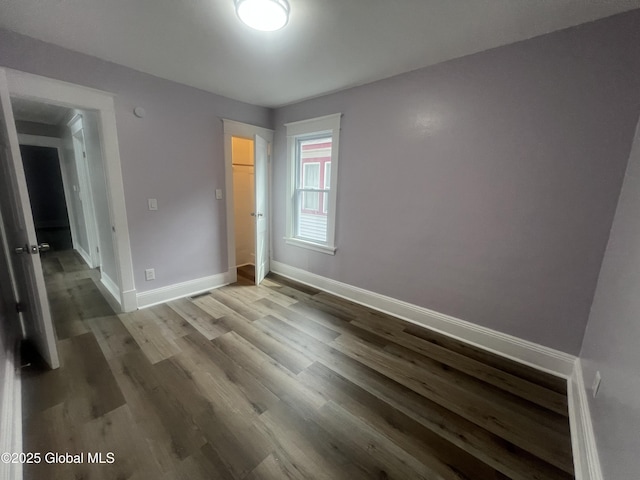 unfurnished bedroom featuring baseboards and wood finished floors