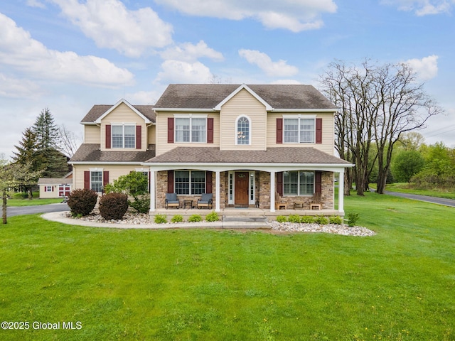 view of front of house featuring covered porch, stone siding, a front lawn, and a shingled roof