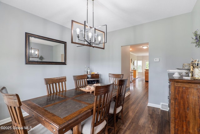 dining room with dark wood-style flooring, baseboards, and a chandelier