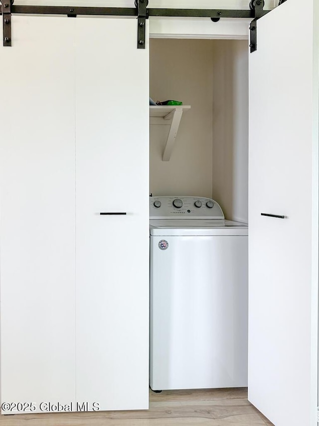 233 Cleverdale Rd, Queensbury, NY 12804 - laundry area featuring washer / clothes dryer, a barn door, and light wood finished floors