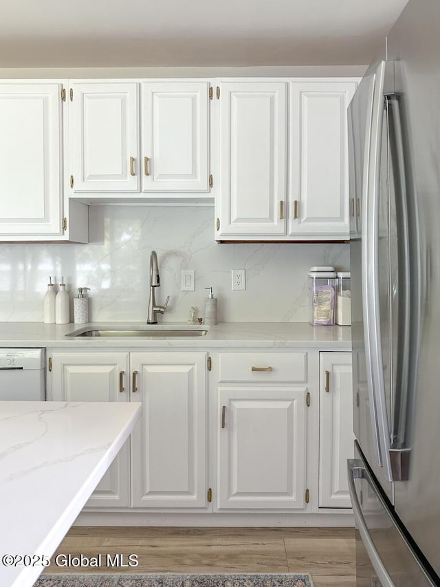 233 Cleverdale Rd, Queensbury, NY 12804 - kitchen with freestanding refrigerator, a sink, white cabinetry, and tasteful backsplash