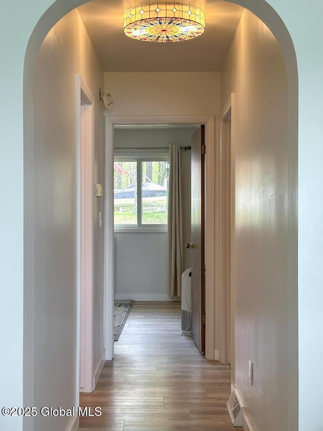 233 Cleverdale Rd, Queensbury, NY 12804 - hallway with baseboards, light wood finished floors, and arched walkways