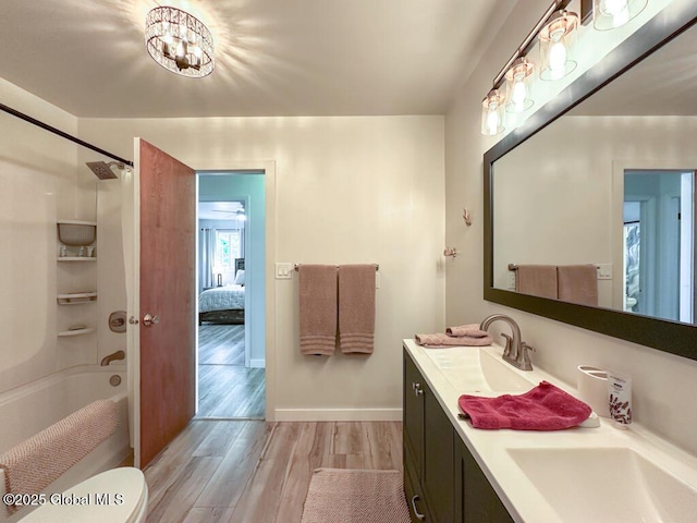 233 Cleverdale Rd, Queensbury, NY 12804 - ensuite bathroom featuring wood finished floors, double vanity, shower / washtub combination, baseboards, and toilet