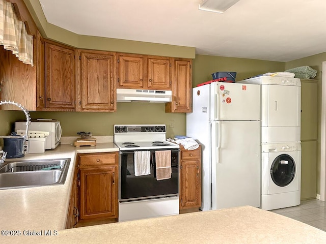 233 Cleverdale Rd, Queensbury, NY 12804 - kitchen with white appliances, under cabinet range hood, estacked washer and dryer, light countertops, and a sink