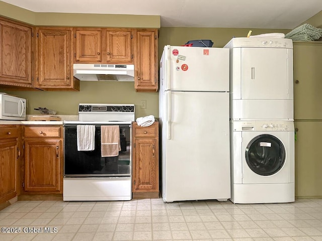 233 Cleverdale Rd, Queensbury, NY 12804 - kitchen with under cabinet range hood, white appliances, estacked washer and dryer, and brown cabinetry