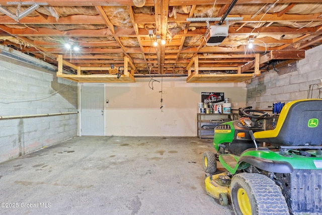 garage featuring a garage door opener and concrete block wall