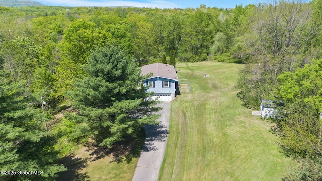 aerial view of property and surrounding area featuring a heavily wooded area
