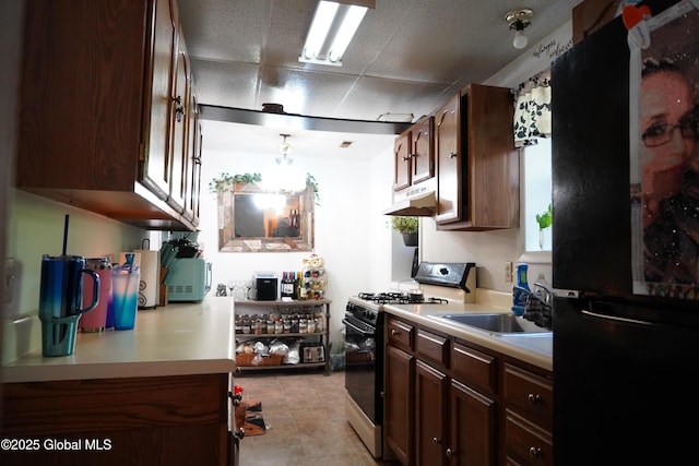 31 Thomas Ave, Hudson Falls, NY 12839 - kitchen featuring gas range oven, freestanding refrigerator, a sink, under cabinet range hood, and light countertops