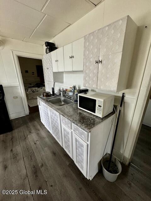 11 Lefferts St, Amsterdam, NY 12010 - kitchen featuring white microwave, a sink, dark wood-type flooring, and white cabinetry