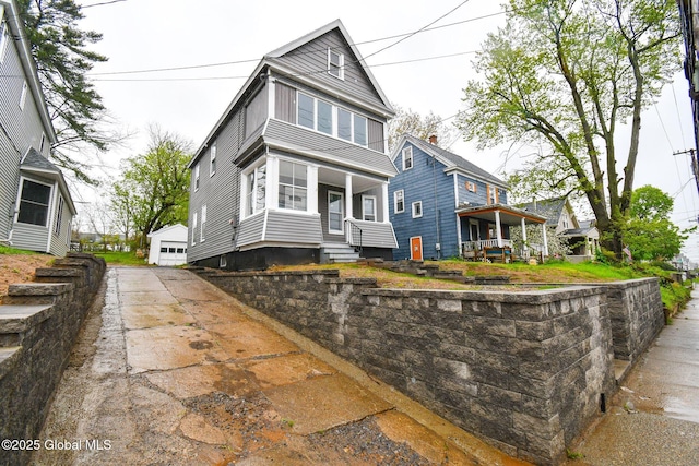 traditional style home with a porch and a detached garage