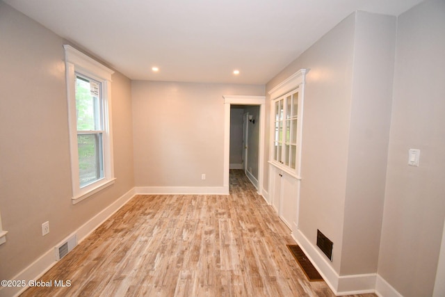 unfurnished room with light wood-type flooring, visible vents, baseboards, and recessed lighting
