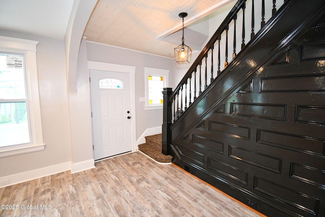 foyer featuring stairway, baseboards, and light wood-style flooring
