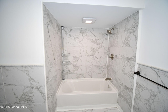 bathroom with marble finish floor and shower / bathing tub combination