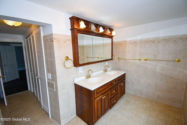 bathroom featuring tile walls, double vanity, and a sink