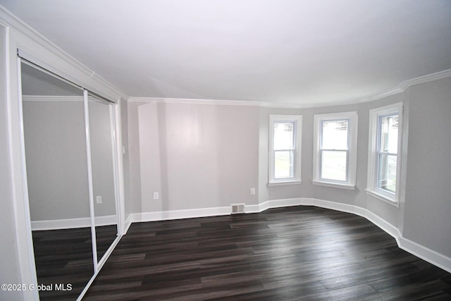 interior space featuring baseboards, crown molding, visible vents, and dark wood-style floors