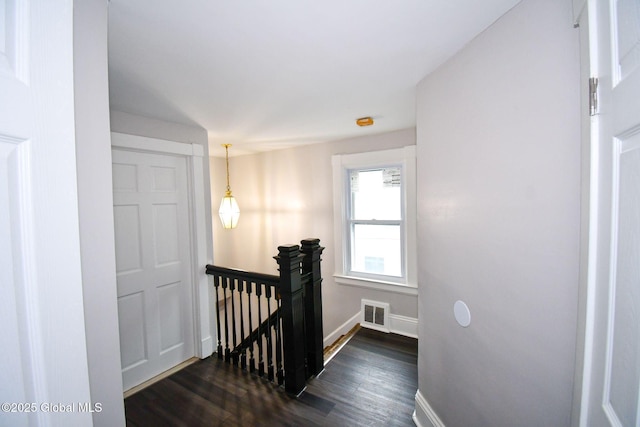 stairway featuring visible vents, wood finished floors, and baseboards