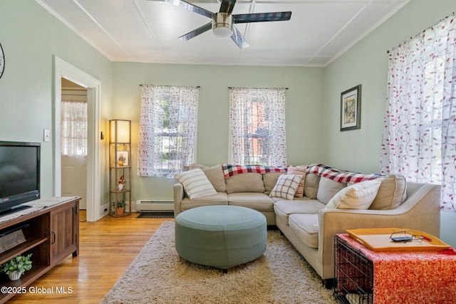 99 Otsego St, Canajoharie, NY 13317 - living area with a baseboard heating unit, ceiling fan, and light wood-type flooring