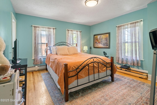 99 Otsego St, Canajoharie, NY 13317 - bedroom featuring a baseboard radiator, a textured ceiling, and light wood-style flooring